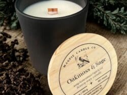 Black candle with wooden lid on burlap.