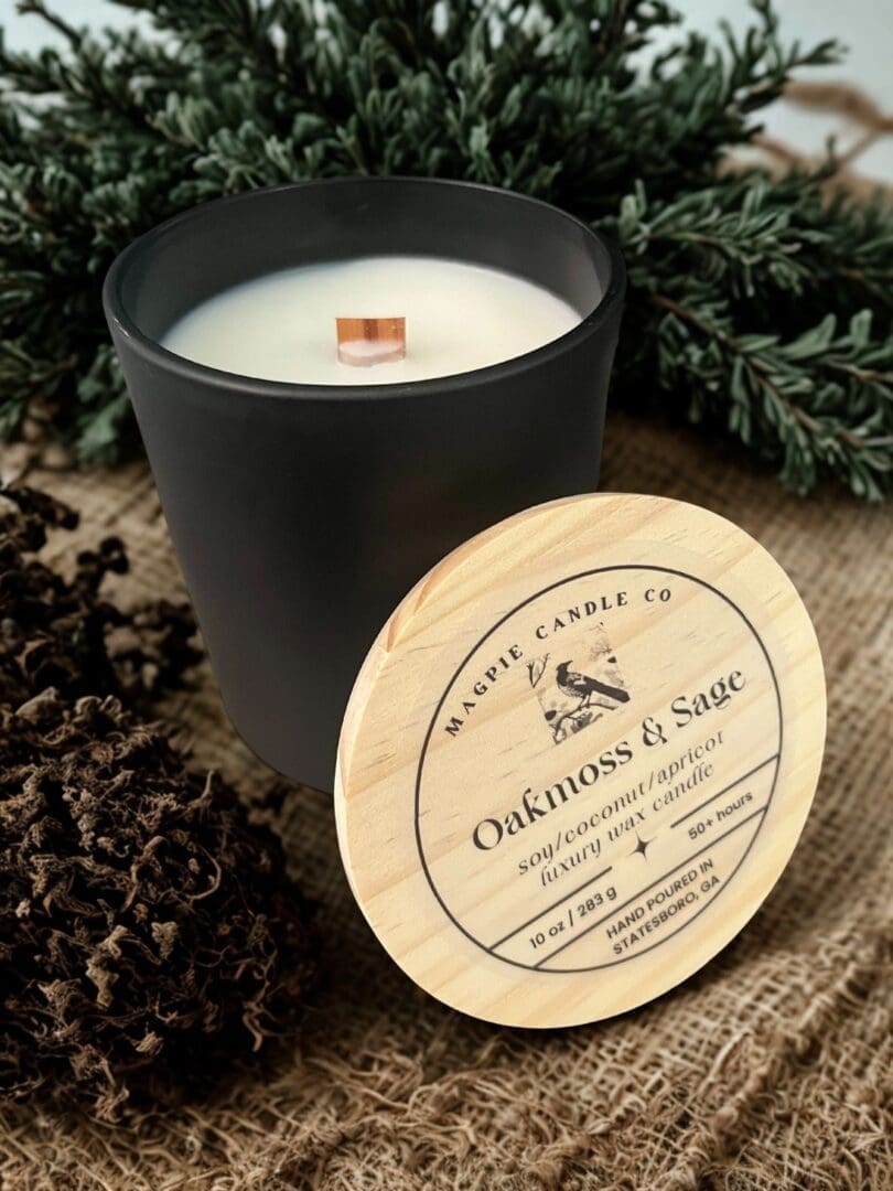 Black candle with wooden lid on burlap.