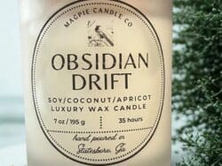 Candle labeled "Obsidian Drift" with plant background.