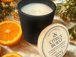 Black candle with oranges and flowers.