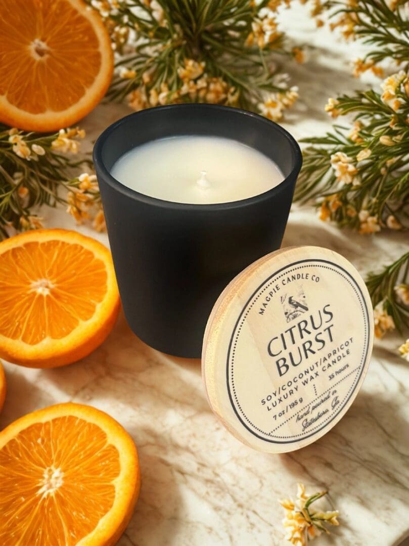 Black candle with oranges and flowers.