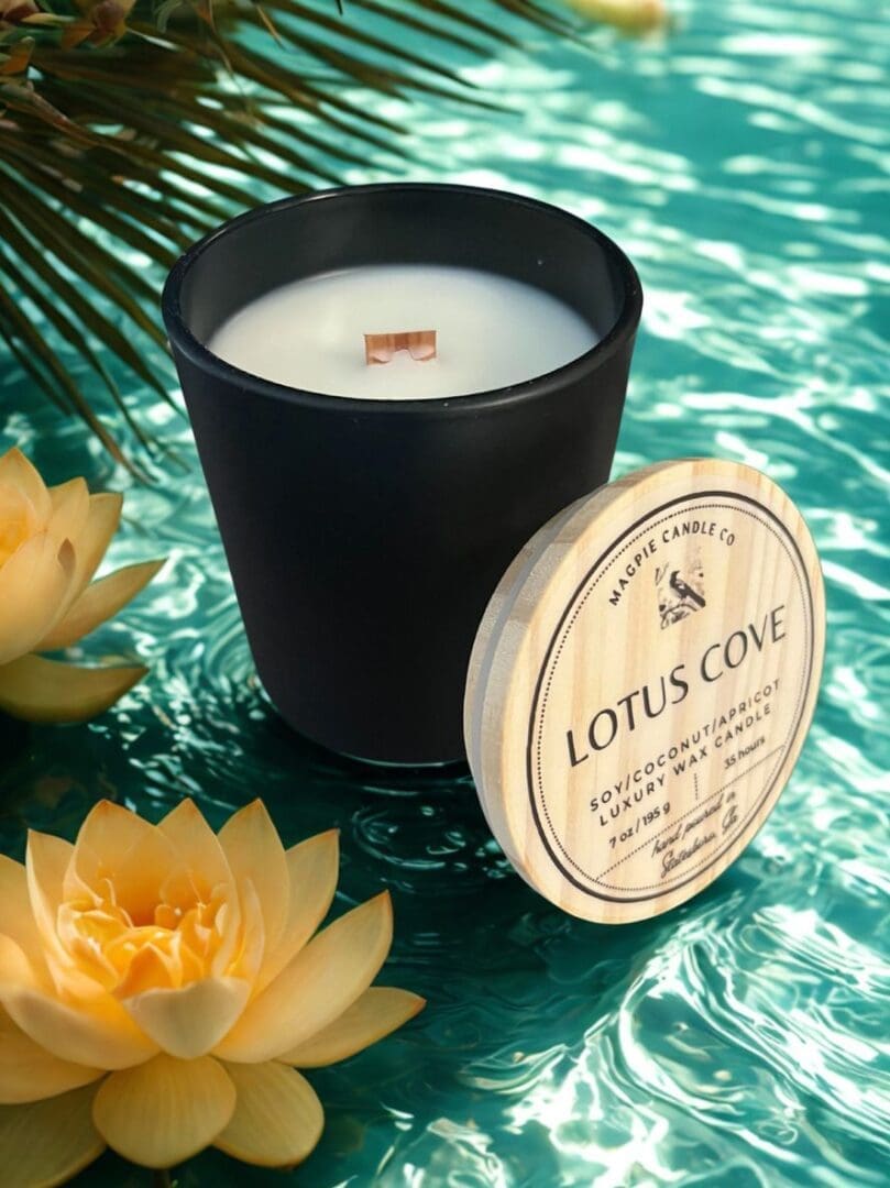Black candle with lotus flowers on water.