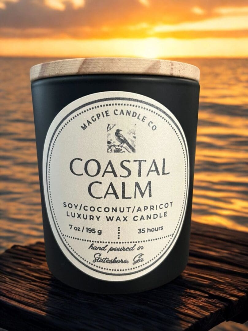 Candle labeled "Coastal Calm" with ocean sunset.